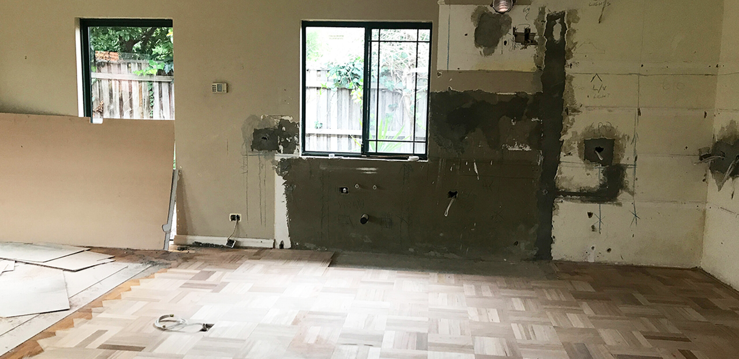 The old kitchen is pulled out, leaving a blank canvas with exposed electrical points and plumbing.
